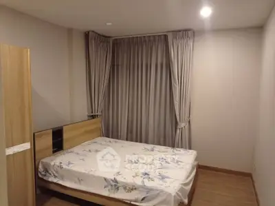 Cozy bedroom with elegant curtains and wooden flooring, perfect for restful nights.