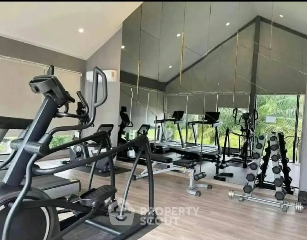 Modern gym with state-of-the-art equipment and mirrored walls in a luxury residential building.