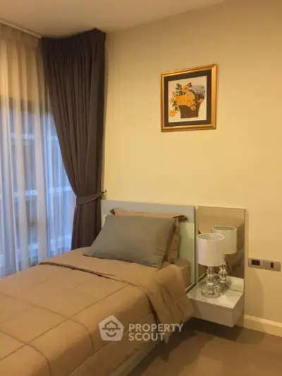 Cozy bedroom with elegant decor and natural light, featuring a single bed and stylish bedside lamp.