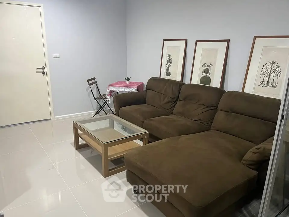 Cozy living room with brown sectional sofa and glass coffee table, perfect for relaxation.