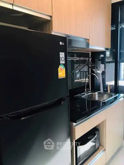 Modern kitchen with sleek black appliances and wooden cabinetry