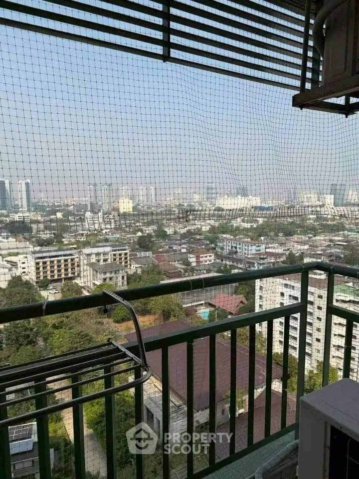 Stunning high-rise balcony view overlooking cityscape with lush greenery and urban skyline.