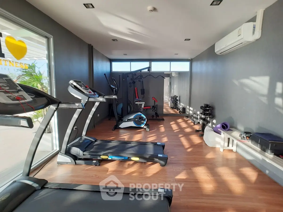 Modern gym with state-of-the-art fitness equipment and bright natural lighting.
