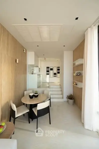 Modern dining area with elegant furniture and natural light in a stylish apartment.