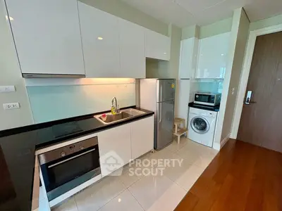 Modern kitchen with sleek appliances and open layout in stylish apartment.