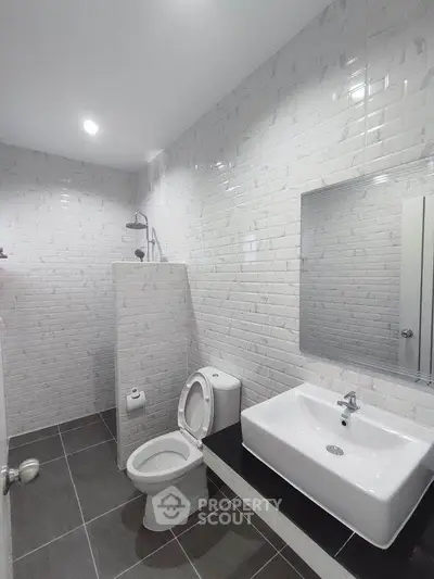 Modern bathroom with sleek white tiles and contemporary fixtures.