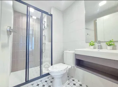 Modern bathroom with glass shower and sleek fixtures in a contemporary apartment.