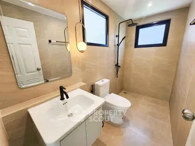 Modern bathroom with sleek fixtures and large mirror in a contemporary home.