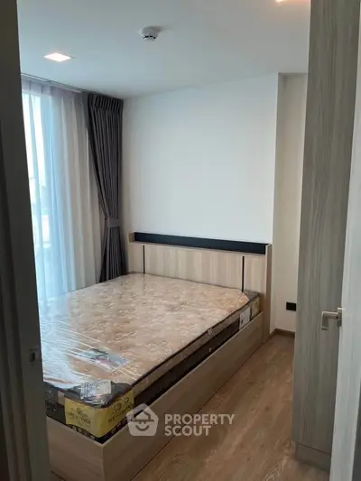 Cozy bedroom with natural light and modern furnishings in a stylish apartment.