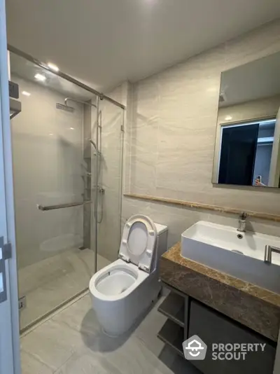 Modern bathroom with glass shower and sleek vanity in luxury apartment