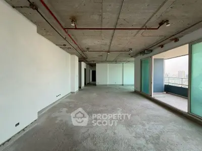Spacious unfinished apartment with concrete ceiling and large balcony view.