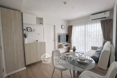 Modern living room with dining area and large window in a stylish apartment.