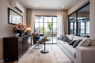 Elegant living room with large windows and stylish decor, featuring a cozy sofa and chic furniture.