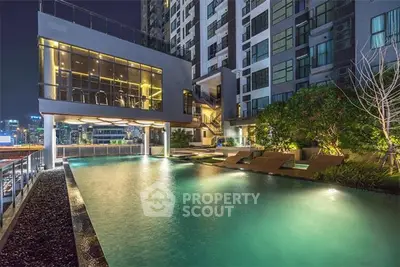 Luxurious condominium with illuminated pool and modern architecture at night.