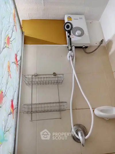 Compact bathroom with electric shower and bird-themed shower curtain