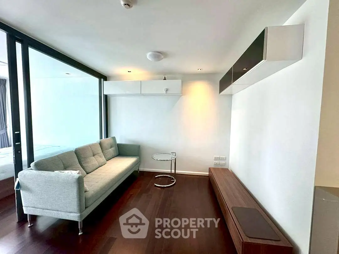 Modern living room with sleek furniture and glass partition, perfect for urban living.