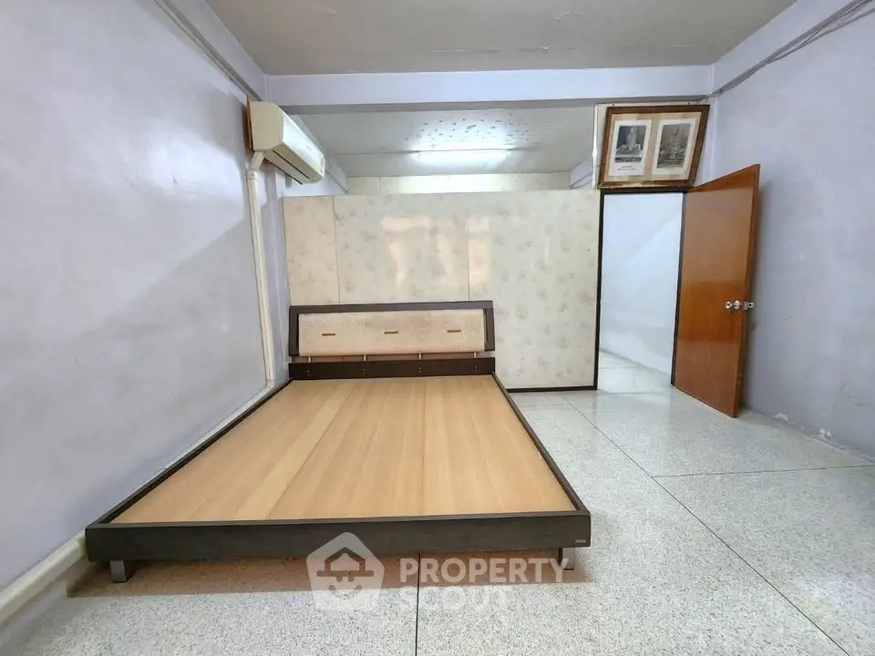 Spacious bedroom with minimalist bed frame and air conditioning