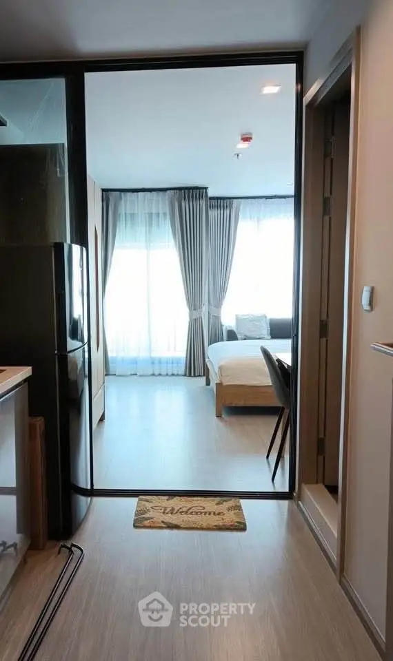 Modern studio apartment with open layout and stylish decor, featuring a cozy bedroom and sleek kitchen area.
