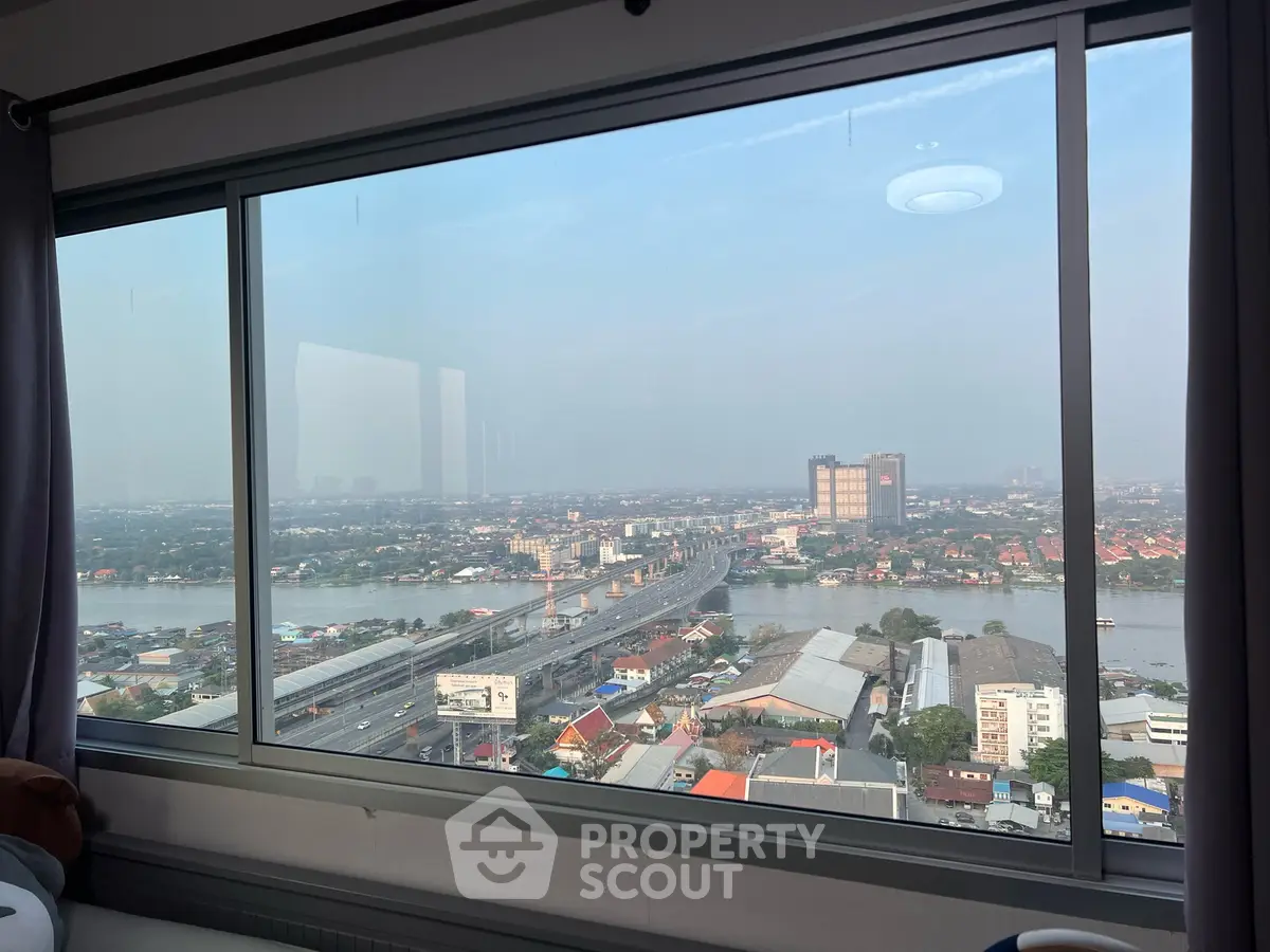 Stunning high-rise apartment view overlooking river and cityscape, perfect for urban living enthusiasts.