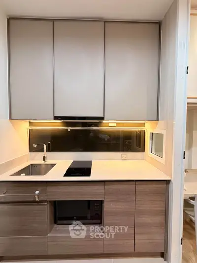 Modern compact kitchen with sleek cabinetry and built-in appliances, ideal for urban living.