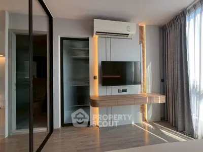 Modern living room with sleek TV setup and large window for natural light