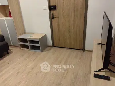 Modern living room with wooden flooring and TV setup, showcasing a cozy and inviting space.