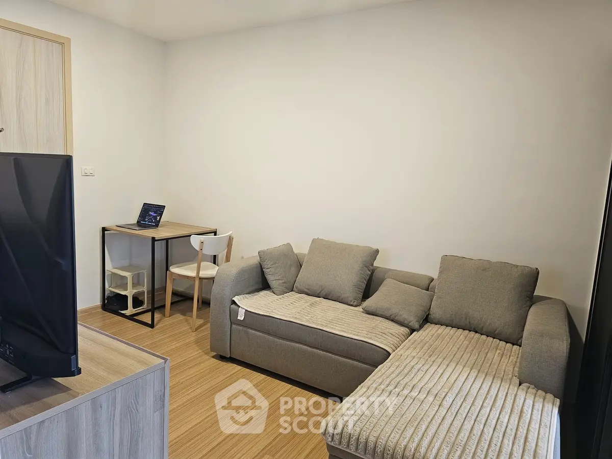 Cozy living room with modern sofa and compact workspace, perfect for urban living.