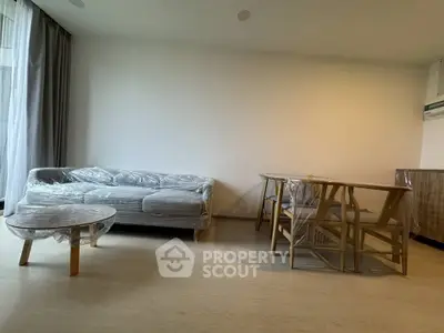 Modern living room with wrapped furniture and natural light