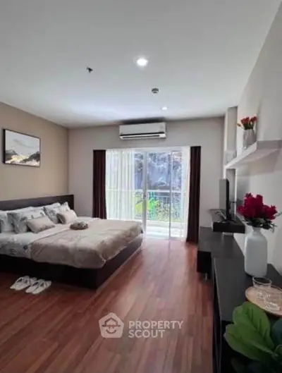 Spacious bedroom with modern decor and balcony access in a stylish apartment.