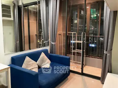 Cozy living room with blue sofa and balcony view in modern apartment