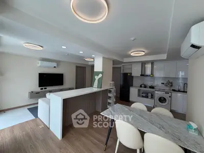 Modern open-layout living room and kitchen with sleek design and stylish lighting