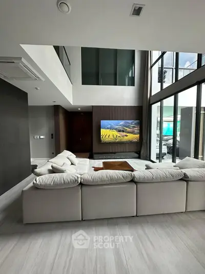 Luxurious modern living room with high ceilings and large windows
