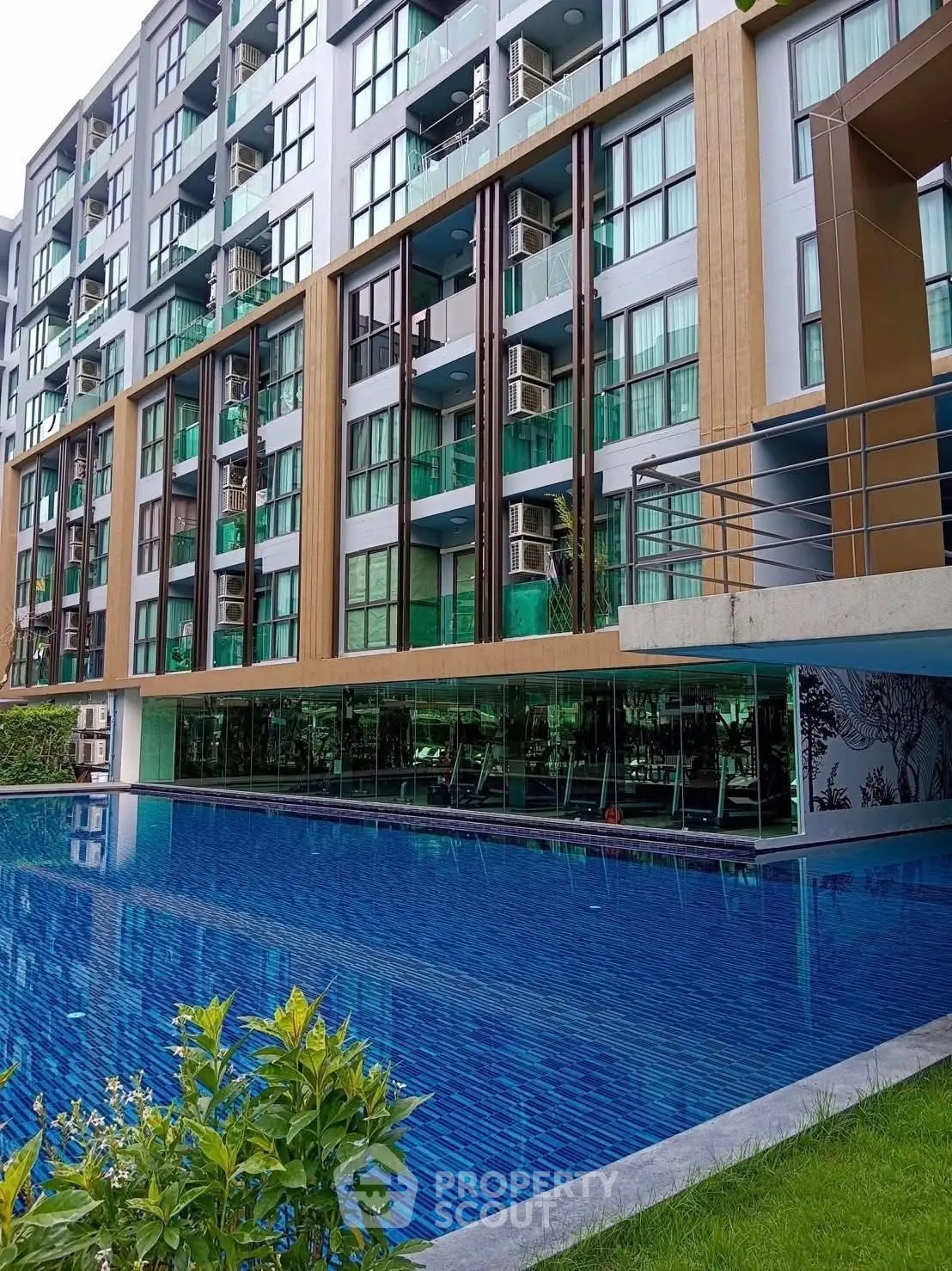 Modern apartment building with a luxurious pool and stylish facade, perfect for urban living.