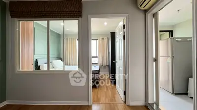 Modern apartment interior with bedroom and kitchen view, featuring sleek design and natural light.