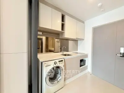 Modern compact kitchen with washing machine and sleek cabinetry