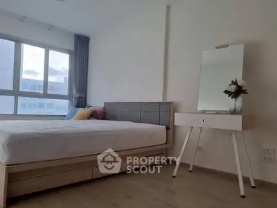 Modern bedroom with stylish furniture and large window offering natural light.