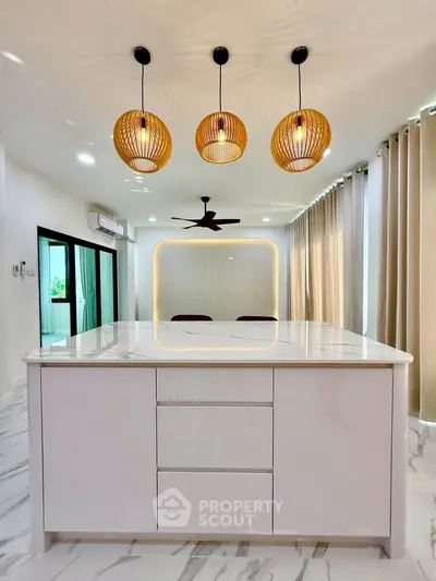 Modern kitchen with sleek island, pendant lights, and marble flooring in a stylish open layout.