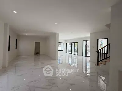 Spacious modern living room with glossy marble floors and large windows.