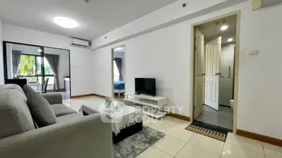 Spacious living room with modern decor and natural light in a stylish apartment.