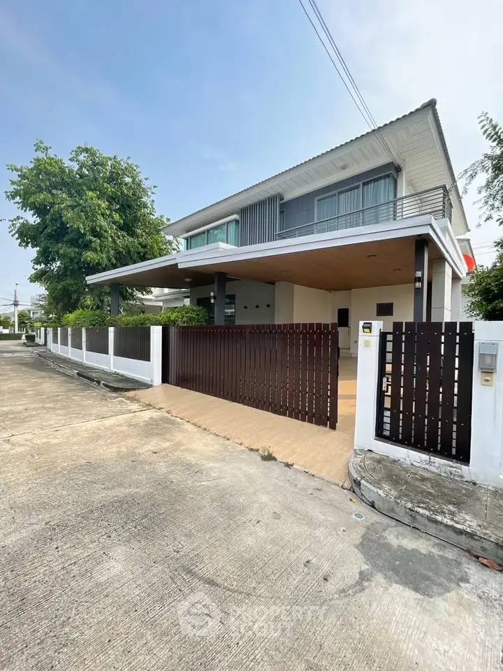 Modern two-story house with spacious driveway and sleek wooden gate.
