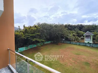 Spacious balcony with serene garden view in a tranquil setting.