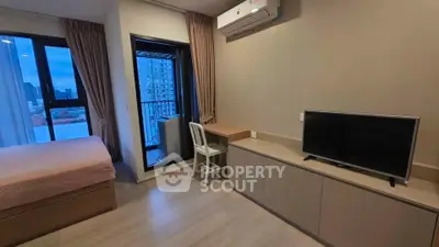 Modern bedroom with balcony view, featuring sleek furniture and air conditioning in a stylish apartment.