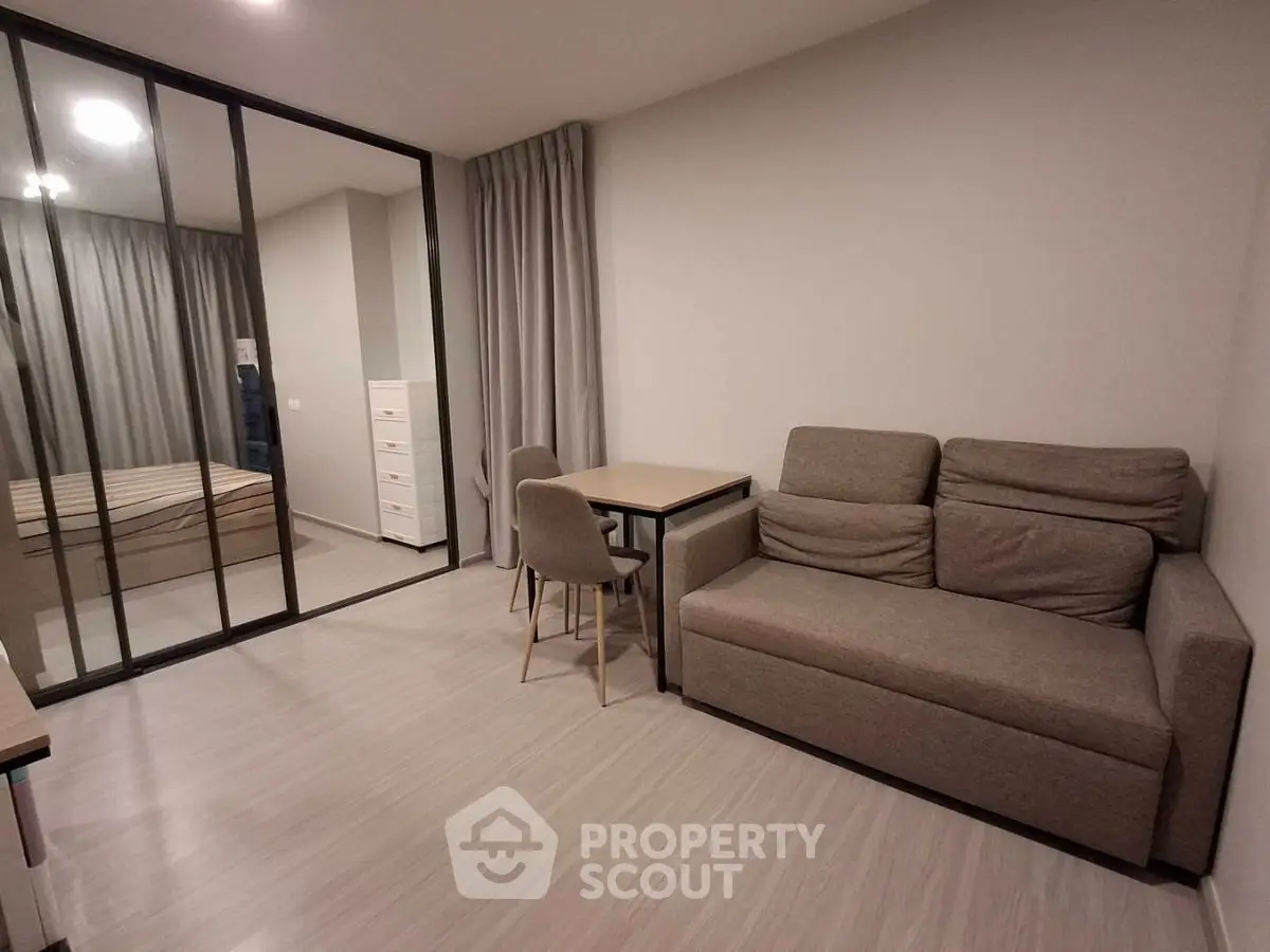 Modern living room with glass partition and cozy furniture in a stylish apartment.