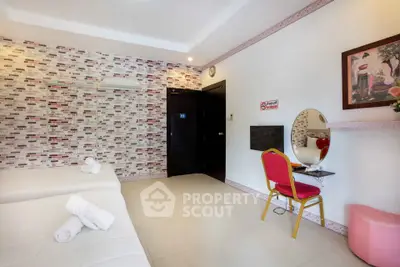 Spacious bedroom with modern decor and stylish brick accent wall, featuring a cozy seating area and elegant furnishings.