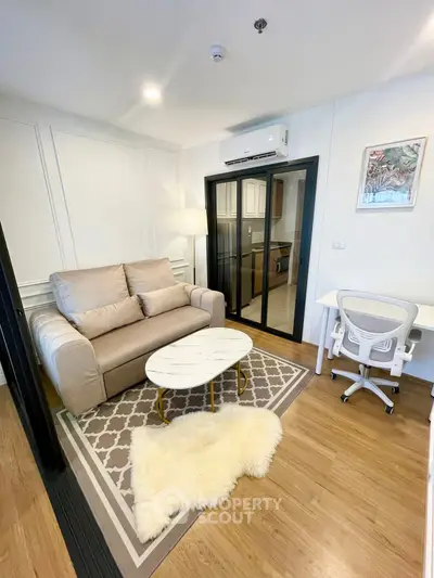 Cozy living room with modern decor, featuring a plush sofa, stylish coffee table, and a glimpse of the kitchen.