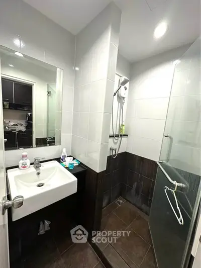 Modern bathroom with sleek shower and stylish sink in contemporary apartment.