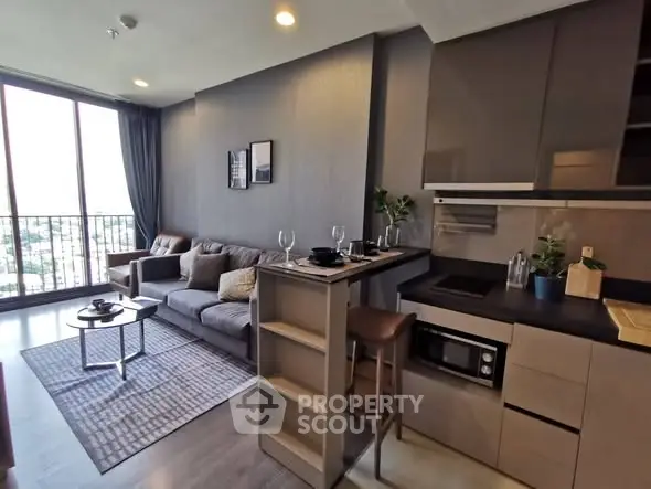 Modern living room with open kitchen and balcony view in stylish apartment.