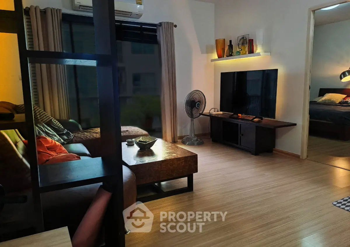 Modern living room with stylish decor and large TV, featuring cozy seating and ambient lighting.