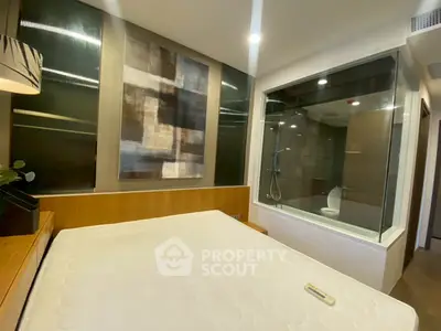 Modern bedroom with glass-walled ensuite bathroom and stylish decor