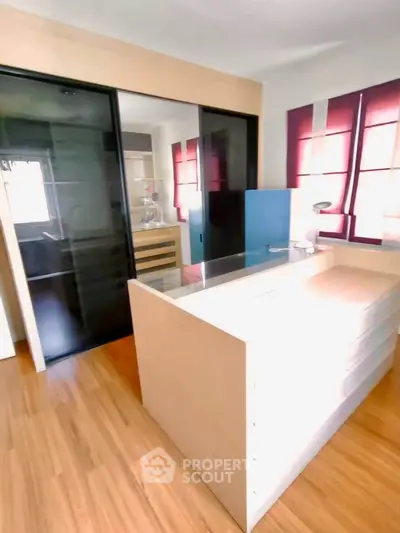 Modern bedroom with sleek sliding glass doors and ample natural light.